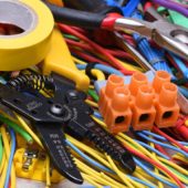 Electrical tools and cables used in electrical installations on grey metal background